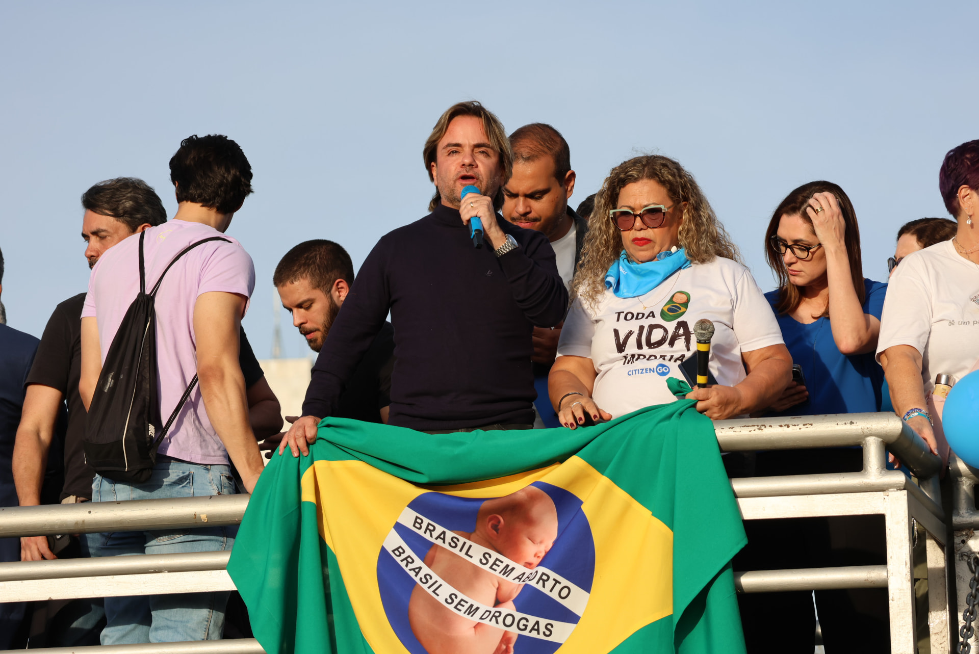 Eros Biondini discursando em ato público ao lado de apoiadores